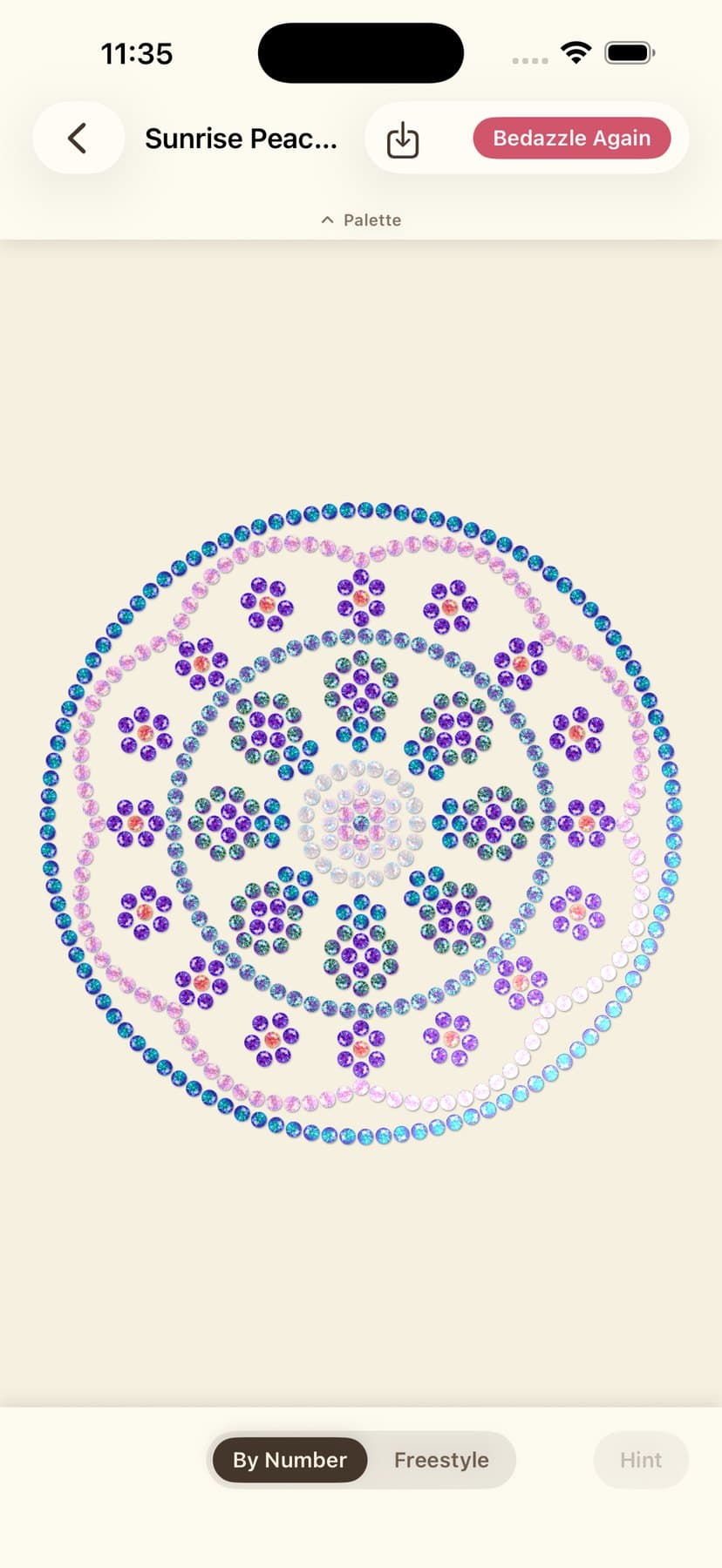 A peacock mandala half filled in with blue and violet gems